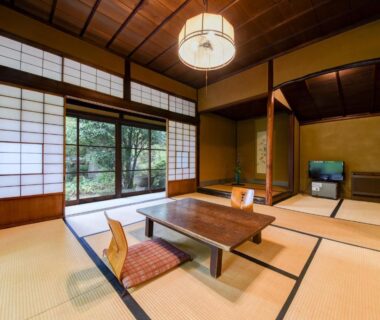 Traditional tatami room with low table, zabuton cushions, shoji screens and garden view at Nagataki in Gifu