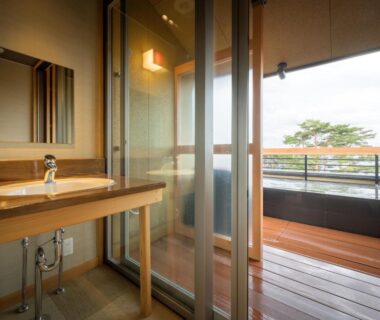 Wooden balcony with soaking tub, glass sliding door, sink and view at Nagisatei Taroan, Iwate, Tōhoku