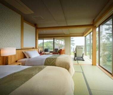 Tatami room with twin beds and sliding glass doors to garden at Nagisatei Taroan in Iwate, Tōhoku