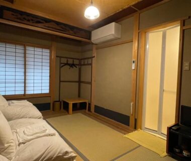 Tatami room with futons and shoji screens at Nagomi-Ryokan Yuu, Kyoto