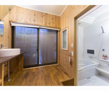Wooden wash area with sink and sliding door, adjoining bathtub and shower at Nagomi-Ryokan Yuu, Kyoto