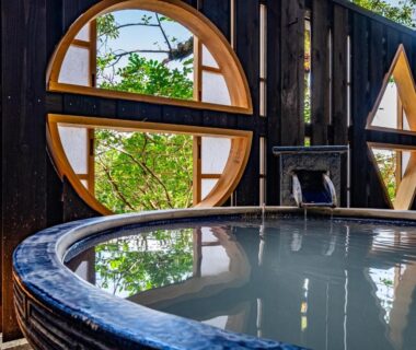 Circular onsen bath framed by round wooden windows at Nagominoyado Hanagokoro Kanagawa
