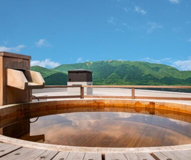 Circular wooden outdoor bath with mountain view at Nagominoyado Hanagokoro Kanagawa