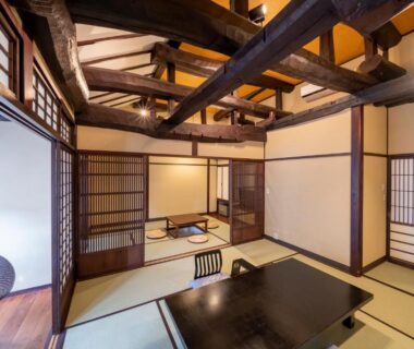 Japanese tatami room with low table, shoji screens and exposed wooden beams at Nakamatsuya Ryokan, Nagano