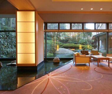 Spacious ryokan lounge with floor-to-ceiling windows overlooking manicured garden and seating area at Nakanobo Zuien in Hyōgo