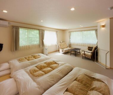Three futon beds on floor with seating area and large windows in a calm Nakaodaira ryokan room, Gifu prefecture