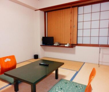 Tatami room with low table, floor chairs and shoji screens at Nakayasu Ryokan in Ishikawa, Chūbu