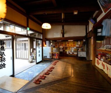 Entrance lobby with wooden floor, reception area and shoe mat at Namegawaonsen Fukushimaya in Tōhoku
