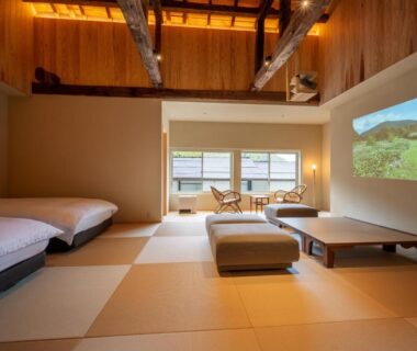 Tatami room with low table, two low beds and projector at Namegawaonsen Fukushimaya, Yamagata