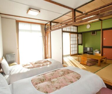 Tatami seating and two Western beds at Nangoku Hotel, Chiba with shoji screens and low table