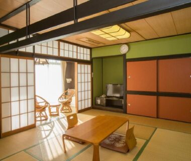 Tatami room with low table, shoji screens and balcony seating at Nangoku Hotel in Chiba