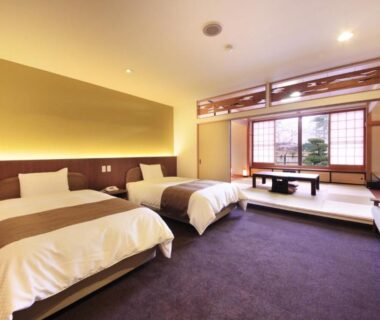 Twin beds and tatami seating alcove at Nanpeidai Onsen Hotel in Tochigi, Kantō, Japan
