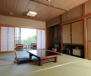 Traditional tatami room with low table, shoji doors and balcony at Nanpeidai Onsen Hotel in Tochigi