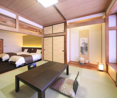 Tatami room with low table, zabuton, two beds, shoji screens and tokonoma at Nanpeidai Onsen Hotel, Tochigi