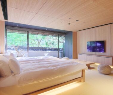 Tatami-style room with low beds and large window overlooking garden greenery at Nanzenji sando KIKUSUI Kyoto
