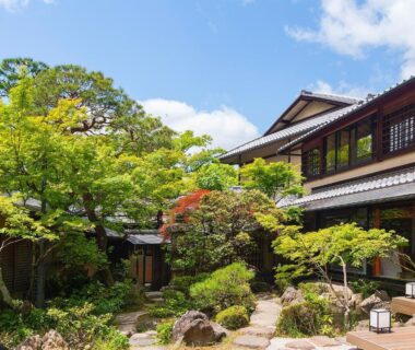 Lush courtyard garden and stone path beside traditional wooden ryokan buildings at Nanzenji sando KIKUSUI in Kyoto
