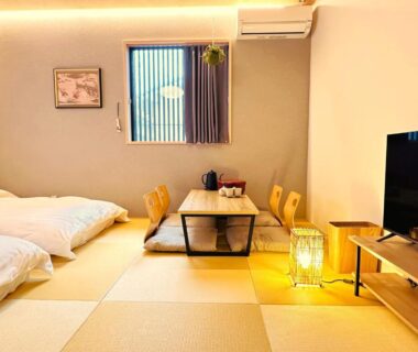 Bright tatami room with futon bedding, low table, cushions and TV at Nara Inn in Kansai Japan