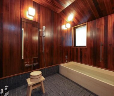 Indoor wood-paneled bath with tub and wooden stool at Nara Kasugaokuyama Tsukihitei, Nara
