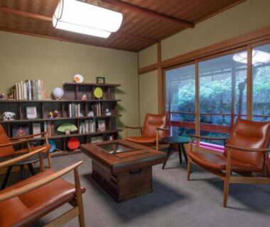 Tatami lounge with low table, chairs, bookshelf and garden view at Nara Kasugaokuyama Tsukihitei, Nara