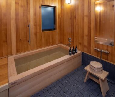 Indoor wooden soaking tub with stool and wall shower at Nara Kasugaokuyama Tsukihitei, Nara