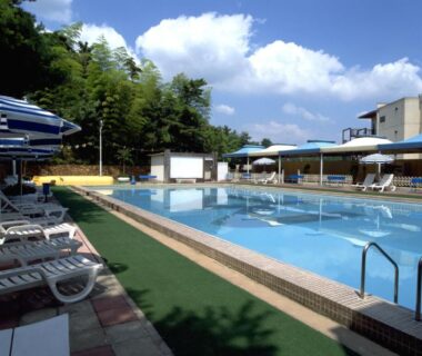 Outdoor pool with lounge chairs and umbrellas at Nara Park Hotel in Nara, Kansai, Japan