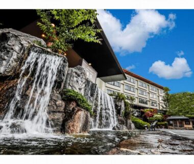Cascading rock waterfall and pond beside Nara Park Hotel in Nara, Kansai under blue sky