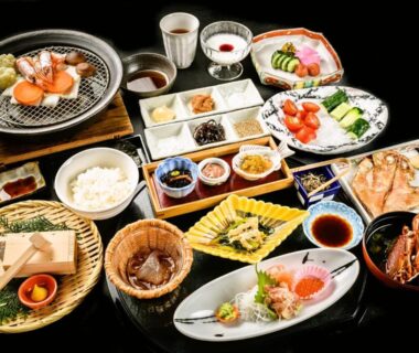 Assorted traditional Japanese dinner dishes arranged on lacquered table at Narashino no sato Gyokusui, Shizuoka