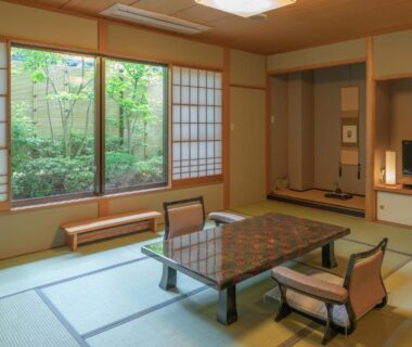 Traditional tatami room with low table, shoji screens and garden view at Narashino no sato Gyokusui in Shizuoka