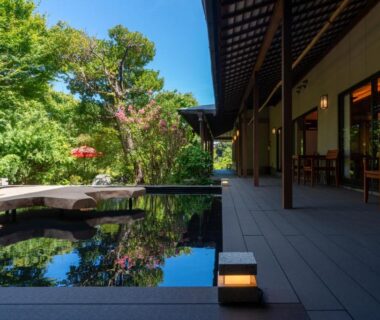 Outdoor reflecting pool beside wooden veranda and garden at Narashino no sato Gyokusui in Shizuoka
