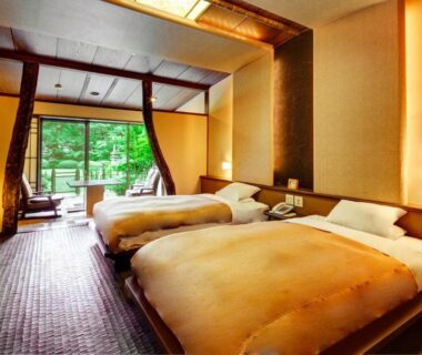 Twin beds on tatami floor with shoji screens and garden-facing balcony at Nasu Onsen Sanraku Tochigi