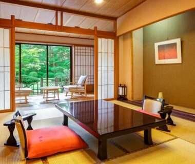 Traditional tatami room with low table and zabuton cushions, shoji doors opening to a tranquil garden at Nasu Onsen Sanraku