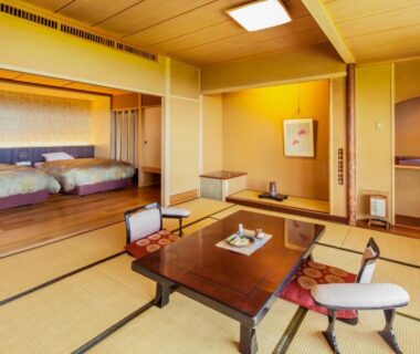 Tatami seating area with low table and twin beds at Nasu Onsen Sanraku, Tochigi, Kantō