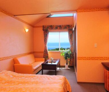 Warm western-style room with bed, sofa, skylight and window overlooking the sea in Shizuoka