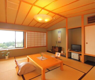 Traditional tatami room with low wooden table, floor cushions, shoji screens and large window at Nasubi no Hana Shizuoka