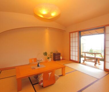 Traditional tatami room with low table, zabuton cushions, shoji doors opening to balcony with outdoor seating