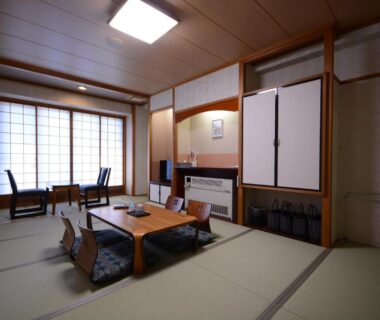 Traditional tatami room with low table, zabuton chairs and shoji screens at Nasushiobara Ichimantei, Tochigi