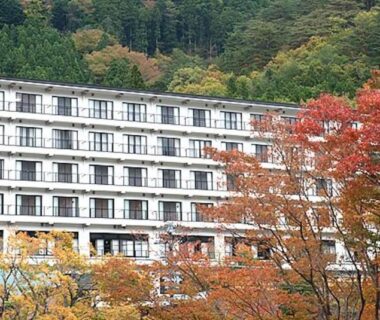Multi-story ryokan nestled among autumn trees on a forested hillside in Nasushiobara, Tochigi, Kantō, Japan