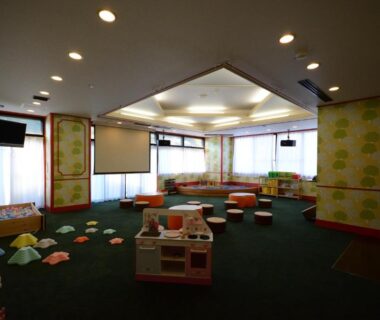 Spacious children's playroom with soft seating, low tables and toys at Nasushiobara Ichimantei, Tochigi
