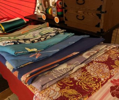 Assorted folded yukata and obi displayed on a table inside Nasushiobara Masudaya ryokan