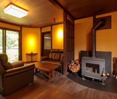 Interior lounge with wood-burning stove, seating area and garden view at Natural Hot Spring Inn Choseian in Wakayama