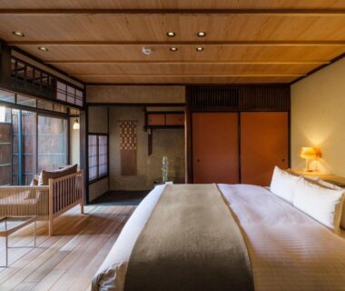 Tatami-style guest room with bed, shoji screens and wooden flooring at Nazuna Kyoto Gosho, Kyoto