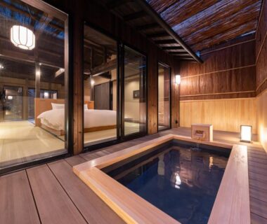 Indoor wooden soaking tub opening to tatami room with futon and sliding doors at Nazuna Kyoto Higashi Honganji