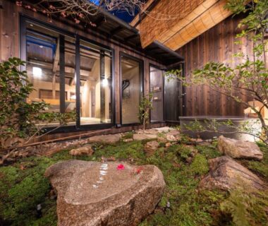 Moss courtyard with stone basin and warm-lit windows at Nazuna Kyoto, Kyoto, Kansai, Japan