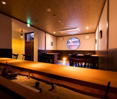 Interior dining area with long wooden counter and round window at Nazuna Kyoto Nijo-jo, Kyoto