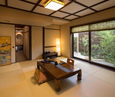 Tatami room with low wooden table, floor cushions and garden view at Nazuna Kyoto Nijo-jo, Kyoto Japan