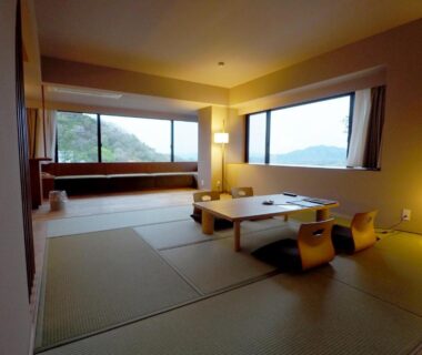 Spacious tatami room with low table and wide windows overlooking a distant landscape at Negiya Ryofukaku Hyōgo
