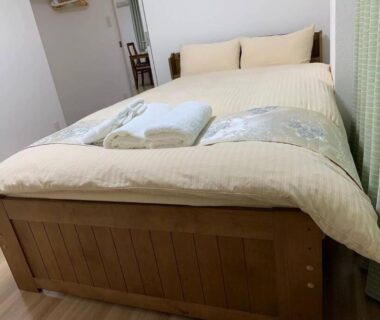 Wooden bed with folded towels in Rosenheim Suite B compact Tokyo ryokan room
