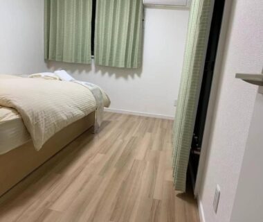 Single bed and wooden floor with green curtains New Open Rosenheim 旅館 スイートルームB無料WIFI Tokyo