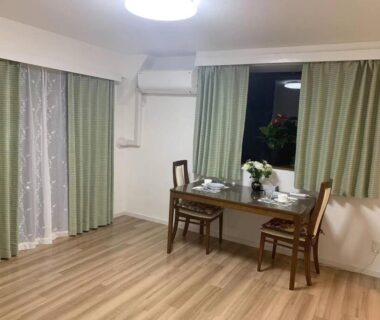 Minimalist room with wooden floor, table and chairs at New Open Rosenheim ryokan in Tokyo