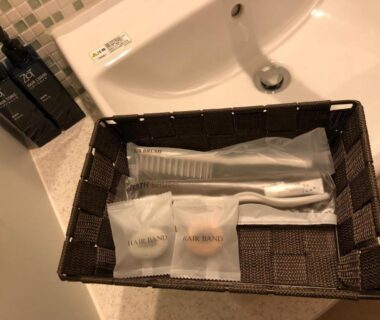 Woven basket with toothbrush, comb and packaged toiletries by sink at New Welcity Yugawara Shizuoka